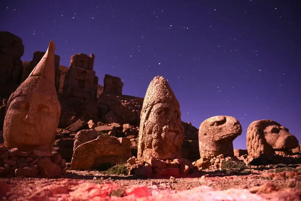 Colossal stone heads of ancient deities resting on the East Terrace of Mount Nemrut at sunrise