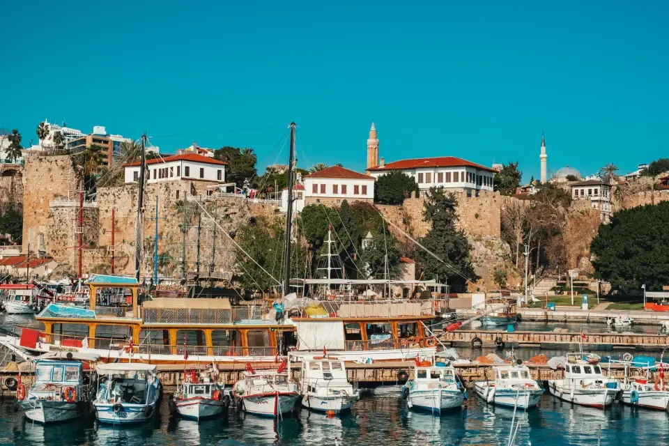 The historic Roman harbor in Old Town filled with wooden gullet boats and surrounded by cliffs