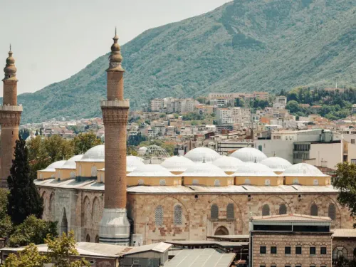 Exterior view of the monumental stone facade and domes of the Bursa Grand Mosque (Ulu Cami)