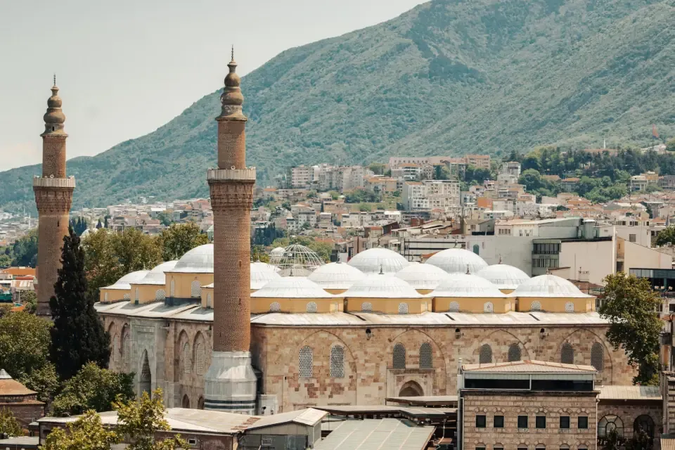 Exterior view of the monumental stone facade and domes of the Bursa Grand Mosque (Ulu Cami)