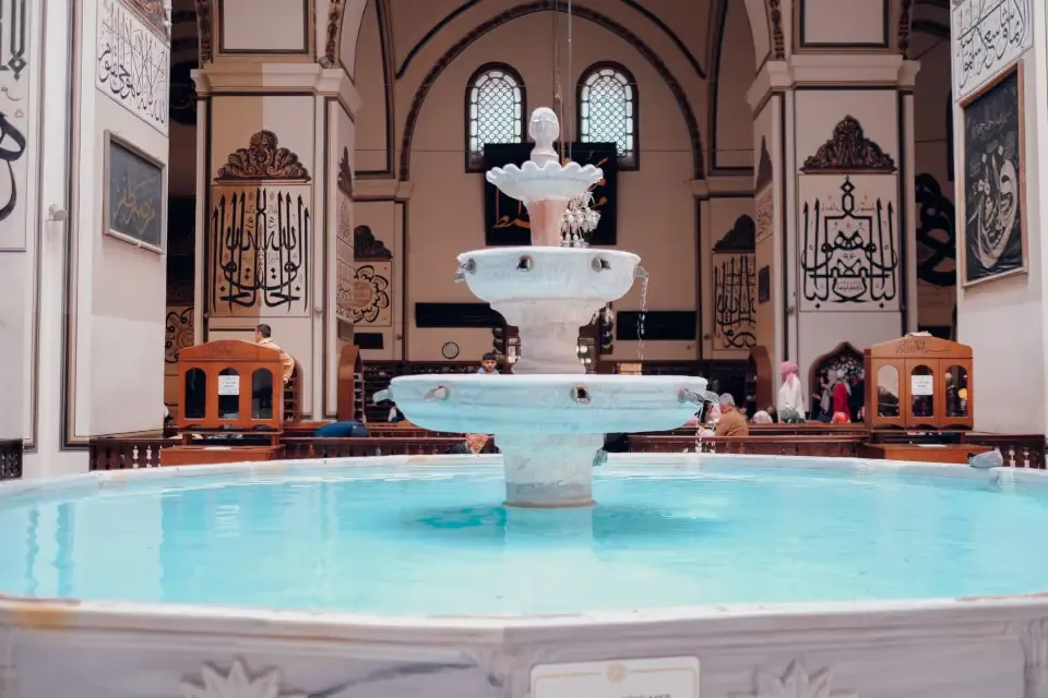 The indoor marble ablution fountain (Sadirvan) under a glass dome inside Ulu Cami