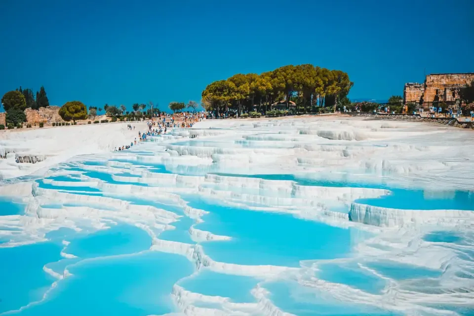 The white calcium travertine terraces and blue thermal pools of Pamukkale