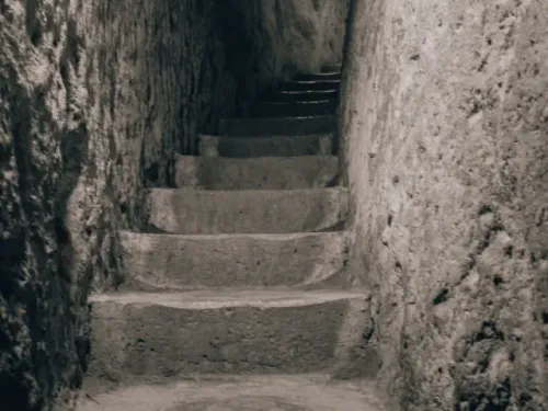 Deep illuminated stone staircases plunging down into Derinkuyu Underground City.