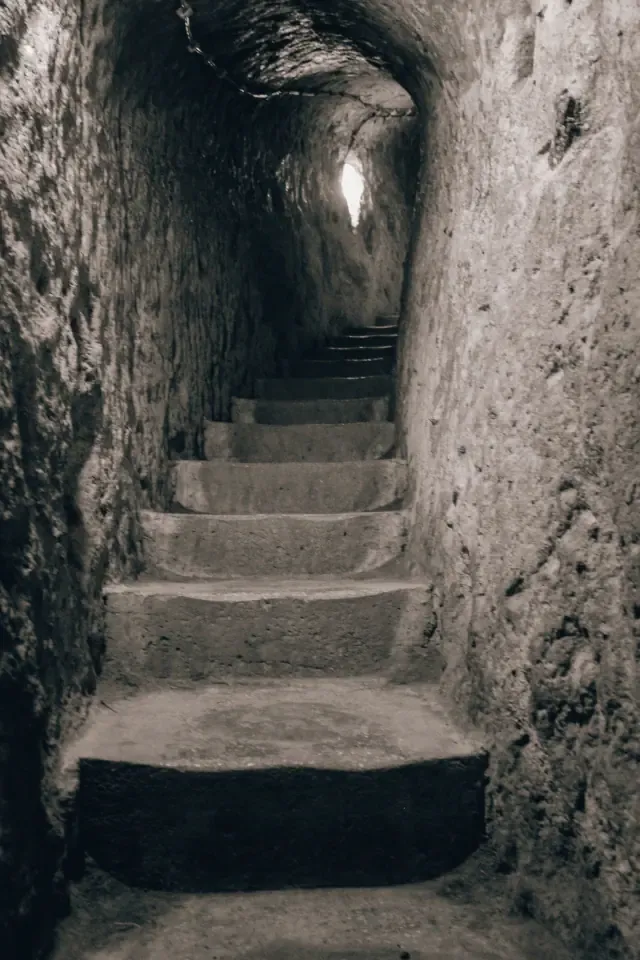 Deep illuminated stone staircases plunging down into Derinkuyu Underground City.