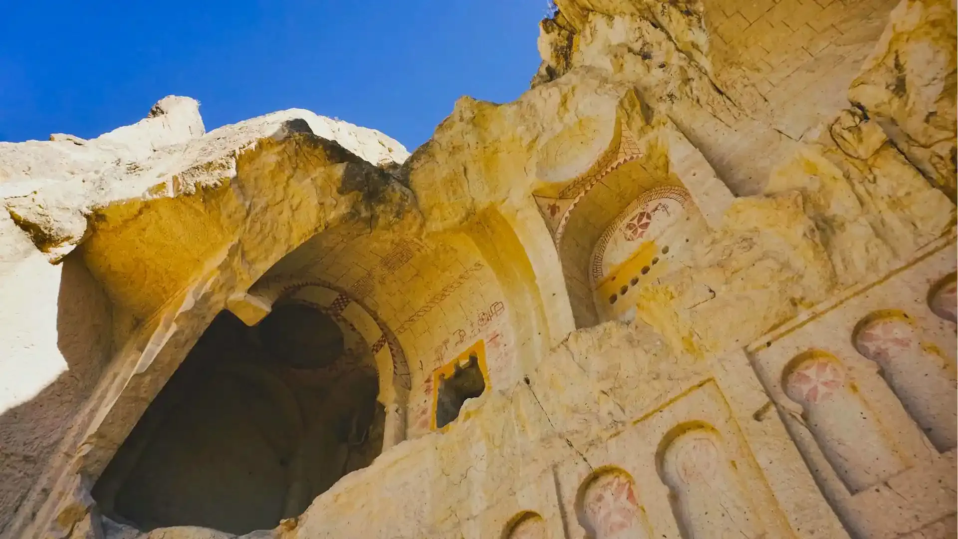 A cave church adorned with Maltese Crosses painted on the soft tufa rock using red ochre painting.