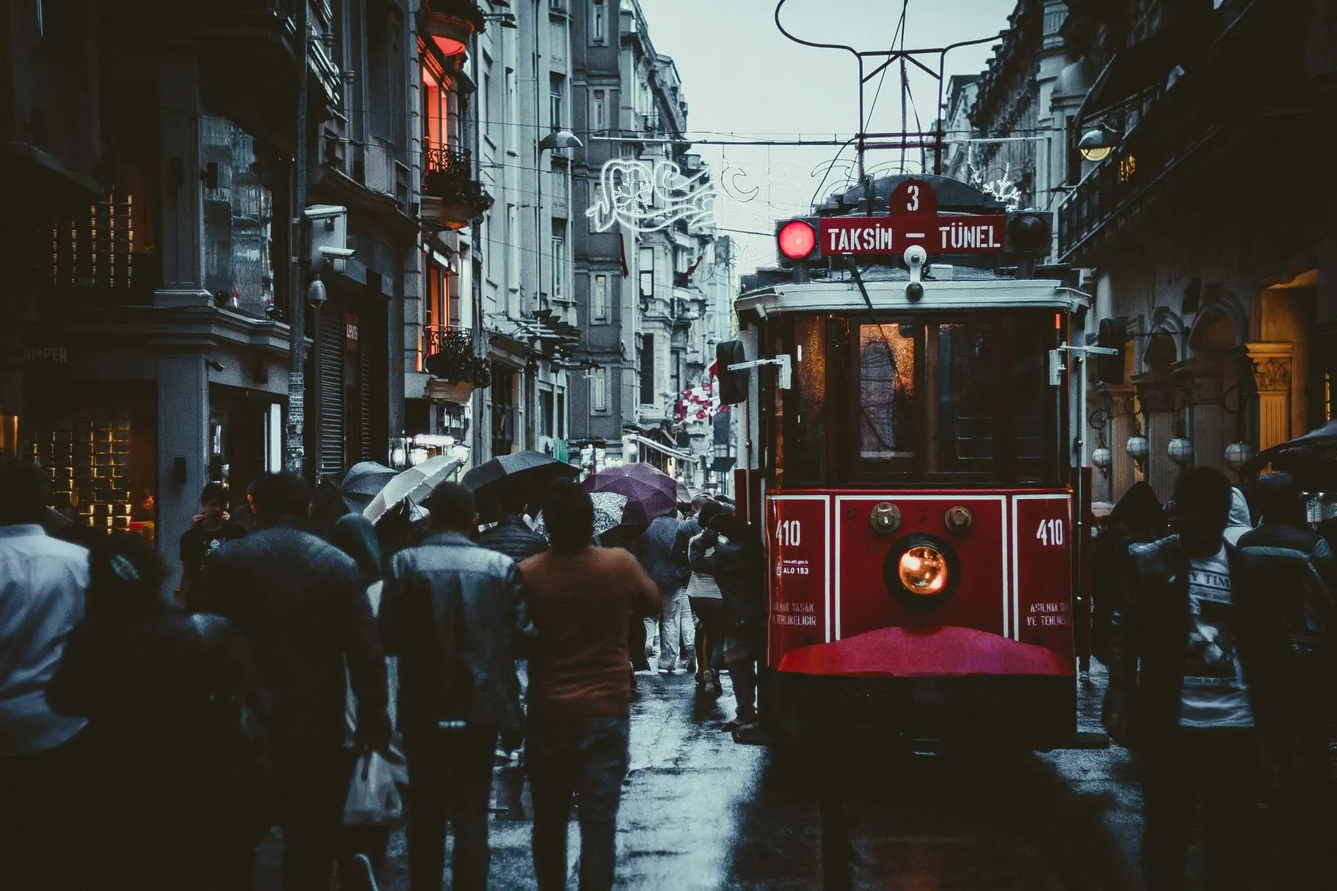 The nostalgic red historic tram driving down pedestrian only Istiklal Street in Istanbul