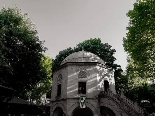Historic two story stone courtyard of Koza Han in Bursa with tea tables under shade trees