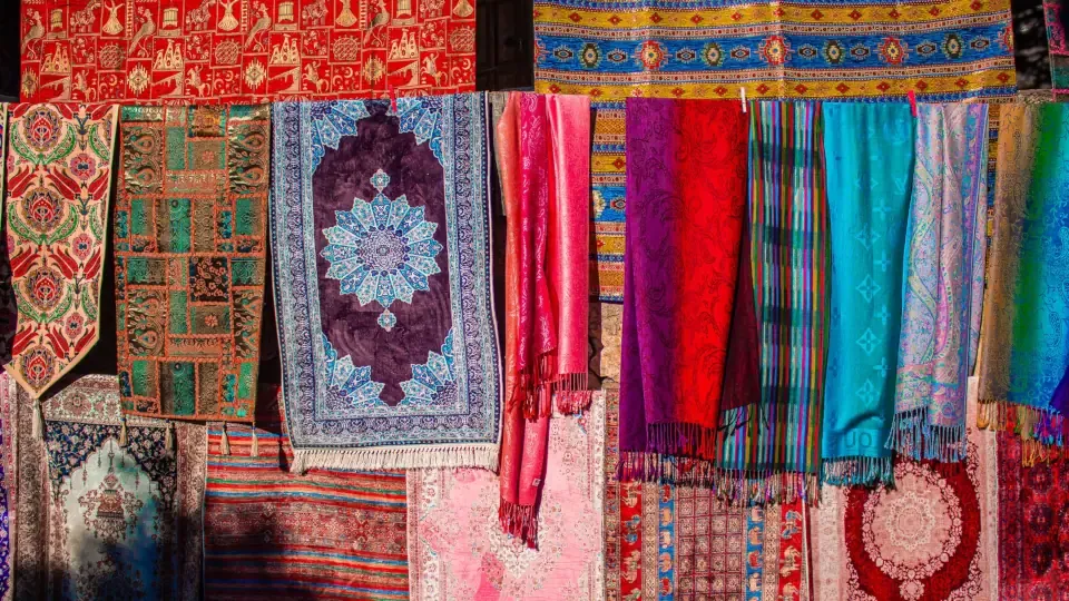 Fine silk scarves and fabrics displayed inside a vaulted stone shop at Koza Han