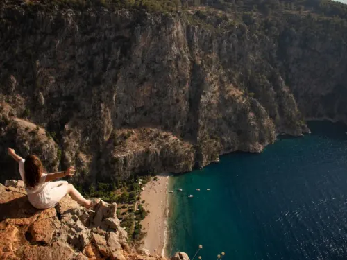 A hiker standing on a scenic ridge overlooking the Lycian Way coastline