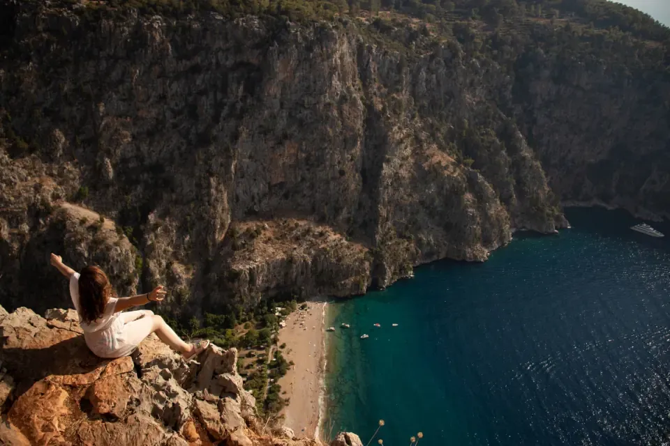 A hiker standing on a scenic ridge overlooking the Lycian Way coastline