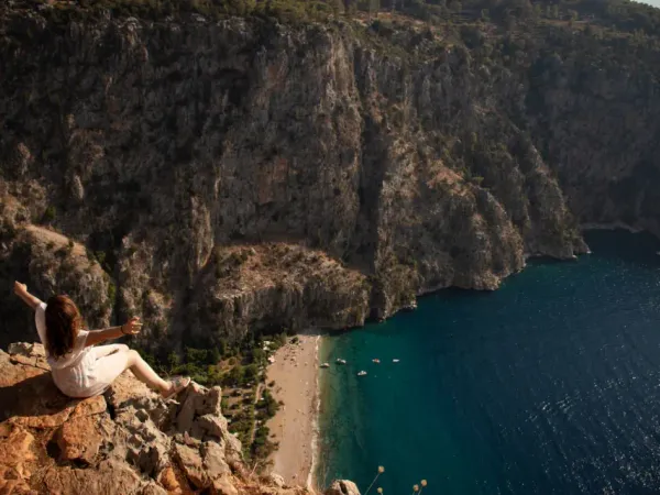 A hiker standing on a scenic ridge overlooking the Lycian Way coastline