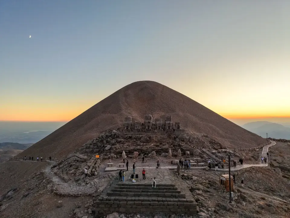 Travelers visiting Mount Nemrut during sunset