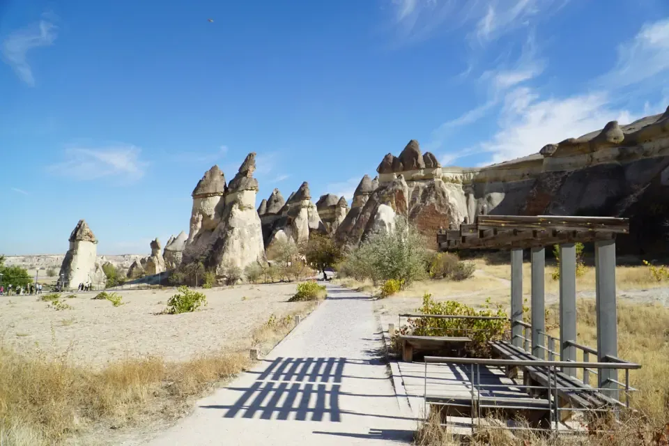 A flat stone pedestrian path meandering between towering mushroom shaped rock formations in Pasabag Valley