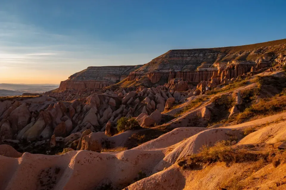 The vibrant pink and orange sunset illuminating the unique rock formations of Red Valley in Cappadocia